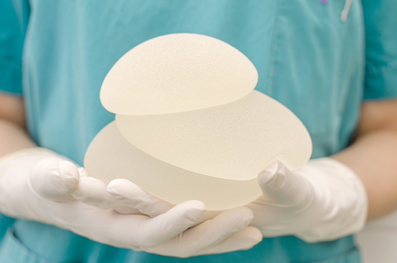 A medical professional holding silicone breast implants